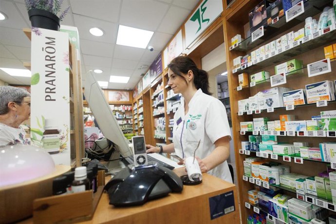 Archivo - Una farmacéutica atiende a una mujer