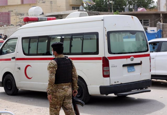 Archivo - Un policía junto a una ambulancia en Bagdad