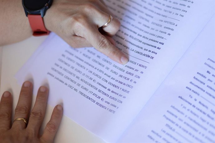 Archivo - Una mujer señala una escritura de compraventa de una hipoteca, a 30 de mayo de 2022, en Madrid (España). 