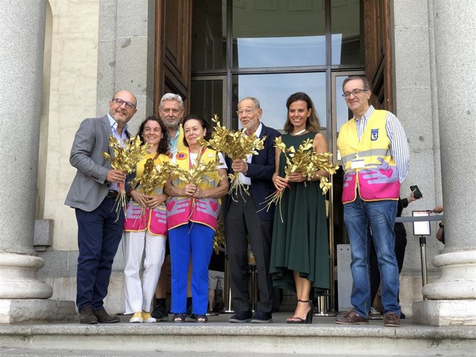 Voluntarios por Madrid junto a José Fernández (izquierda), Almudena Maíllo (segunda por la derecha) y Javier Solana (centro) posan con los ramos que han entregado a los visitantes del museo.