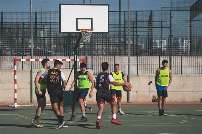 Archivo - Jóvenes practicando baloncesto por la tarde en una imagen de archivo.