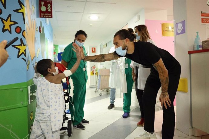 El futbolista del Córdoba CF Dragui Gudelj saluda a un niño durante su visita al Hospital Reina Sofía.