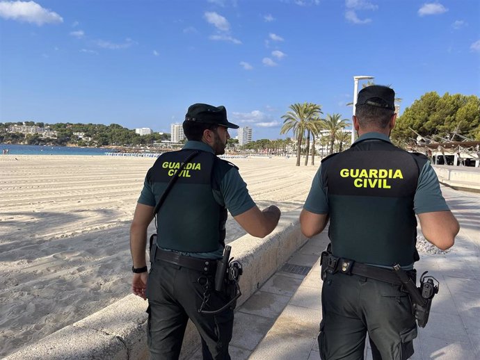 Archivo - Dos guardias civiles pasean por una playa de Ibiza.