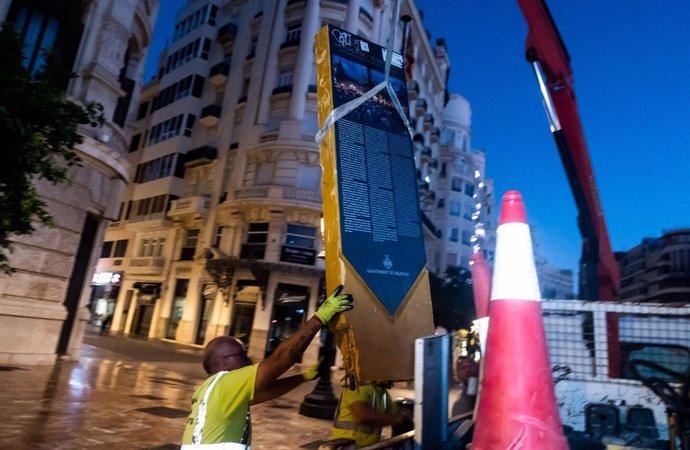 Miembros de la contrata de conservación, reparación y renovación de los firmes y pavimentos de las calles y caminos de Valncia retiran el monolito del 15-M de la plaza del Ayuntamiento.