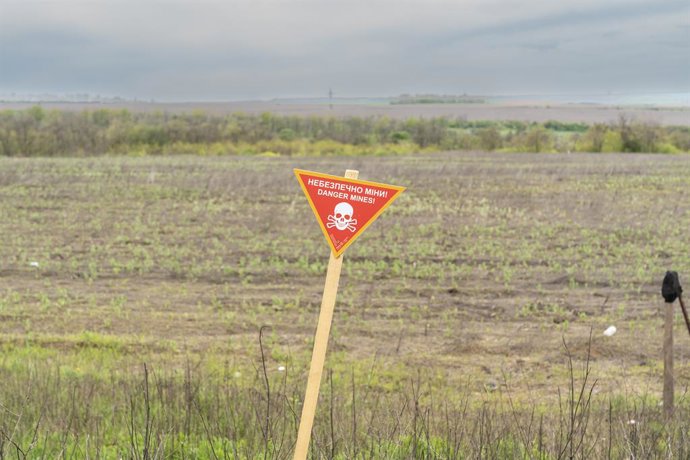 Archivo - May 8, 2023, Kharkiv region, Ukraine: Warning sign about possible mines in the fields and side of roads seen near village of Kamyanka in Kharkiv region of Ukraine