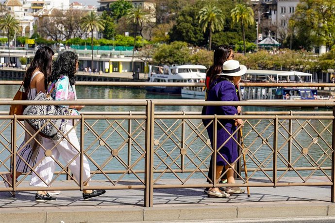 Archivo - Traseúntes por el Puente de San Telmo  en un día donde continúa el tiempo seco y soleado a 10 de abril del 2023 en Sevilla. 