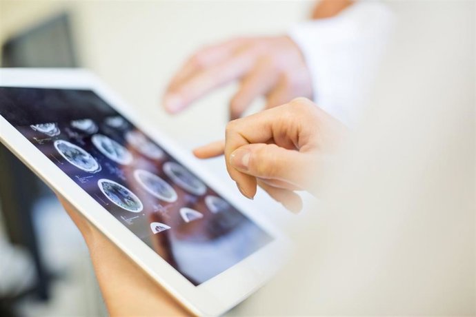 Archivo - Close up of doctors hands pointing at brain xrays images on digital tablet. Medical team in clinic analyzing MRI scans on digital tablet.