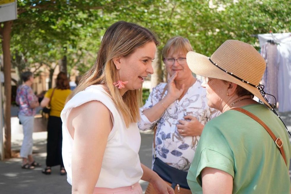 La presidenta del Govern, Marga Prohens, charla con un grupo de personas mayores.