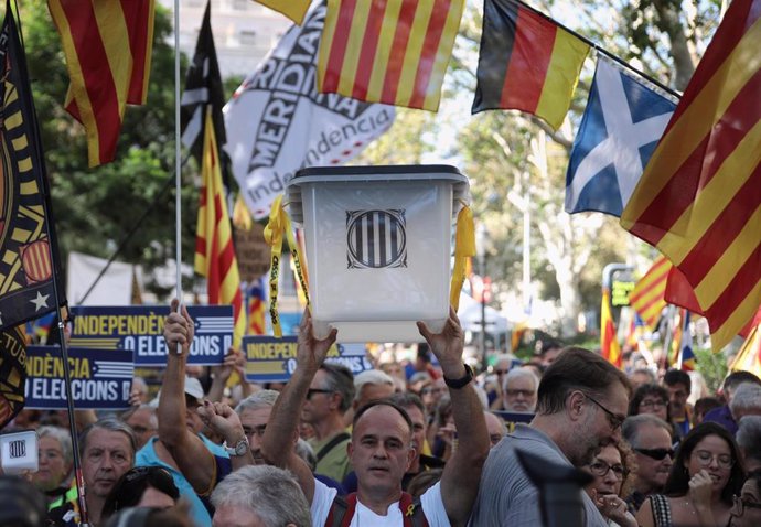 Manifestante alzando una urna en la manifestación de la ANC por el sexto aniversario del 1-O