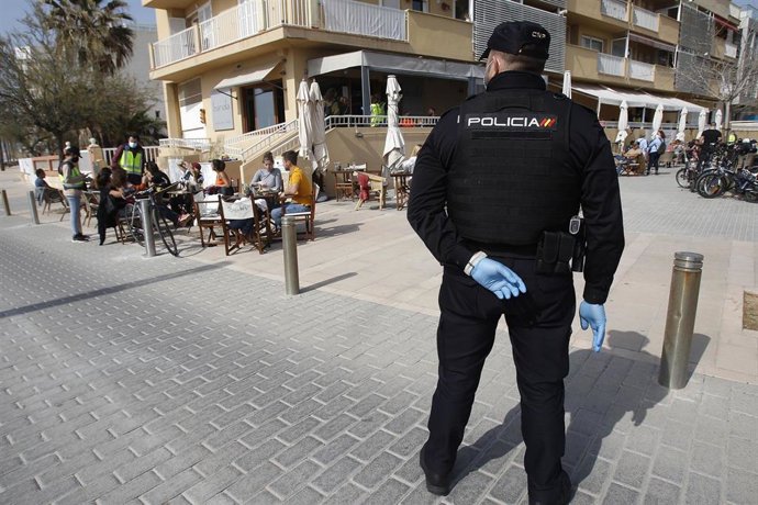 Archivo - Un agente de la Policía Nacional durante un control a una terraza de un restaurante de Palma.