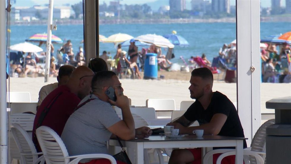 Archivo - Un hombre hablando por el móvil en una playa de Valencia