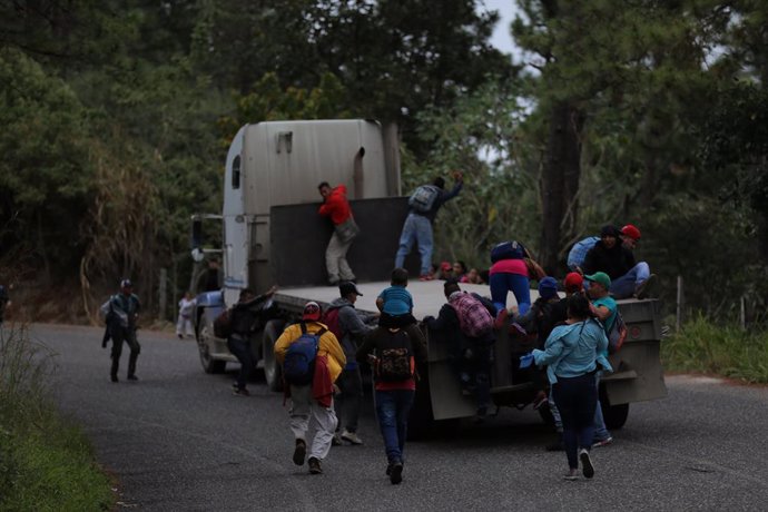 Archivo - 16 January 2019, Guatemala, Aguas Calientes: Migrants from Honduras jump on a truck to continue their way north plans to immigrate to the USA during a so-called migrant caravan. According to the government of Honduras, 700 people entered Guate