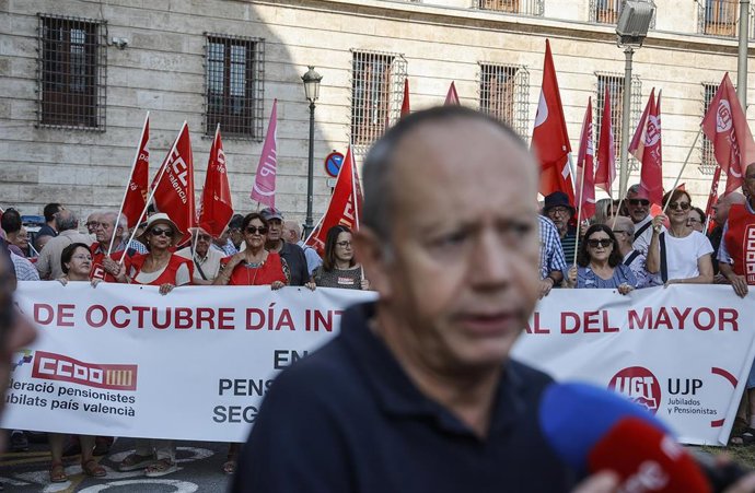 Varias personas sujetan una pancarta mientras el secretario general de UGT PV, Ismael Sáez ofrece declaraciones a los medios durante una concentración para exigir un refuerzo de los servicios públicos y una atención digna a las personas mayores