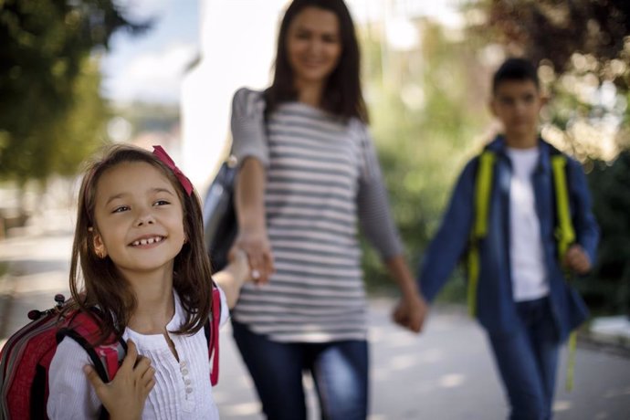 Archivo - Madre e hijos de camino al colegio. Andar