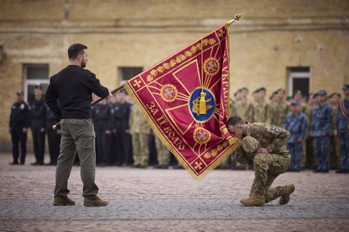 October 1, 2023, Kyiv, Kiev Oblast, Ukraine: Ukrainian President Volodymyr Zelenskyy, left, presents a battle flag to a soldier as he kisses during the celebration of the Day of Defenders of Ukraine at the Kyiv Fortress, October 1, 2023 in Kyiv, Ukraine.