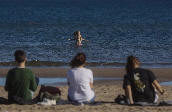 Archivo - Dos chicas se bañan en la playa en Valncia