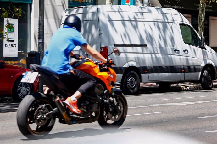 Archivo - Un hombre circula en su moto por una calle de Madrid.