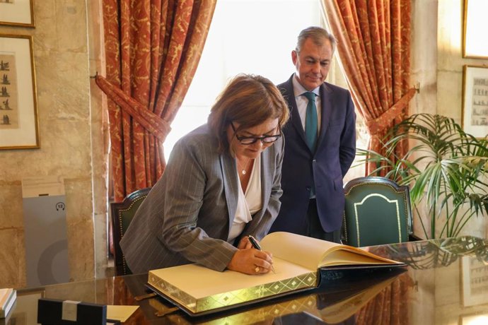 La comisaria de Transportes de la UE firma en el Libro de Honor del Ayuntamiento en presencia del alcalde hispalense.