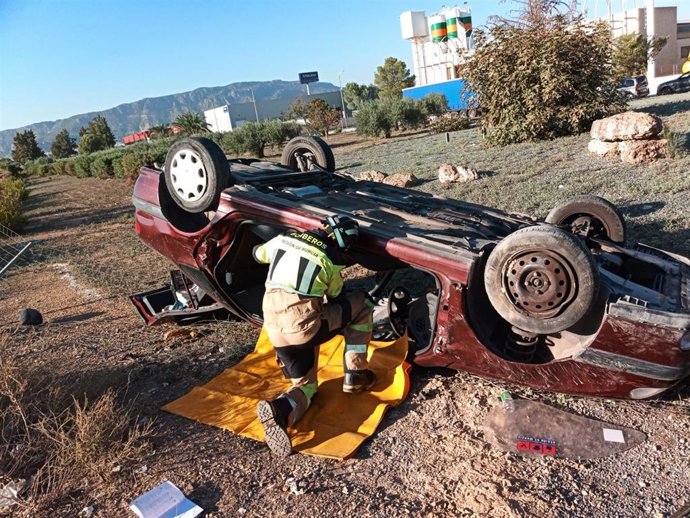 Un efectivo del CEIS trabaja para sacar al herido del vehículo siniestrado