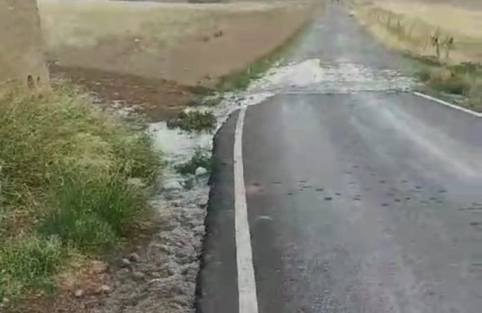 Rotura en el depósito en Peñarroya por el que se vierte agua, que llega a la carretera de acceso.