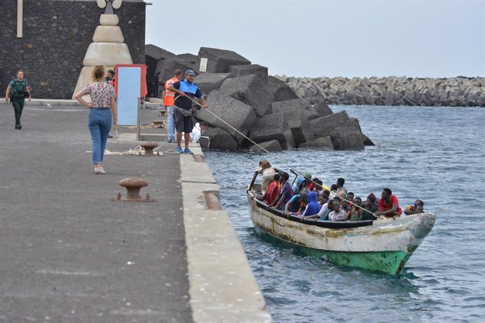 Varias personas llegan en un cayuco al muelle de La Restinga, en la isla de El Hierro