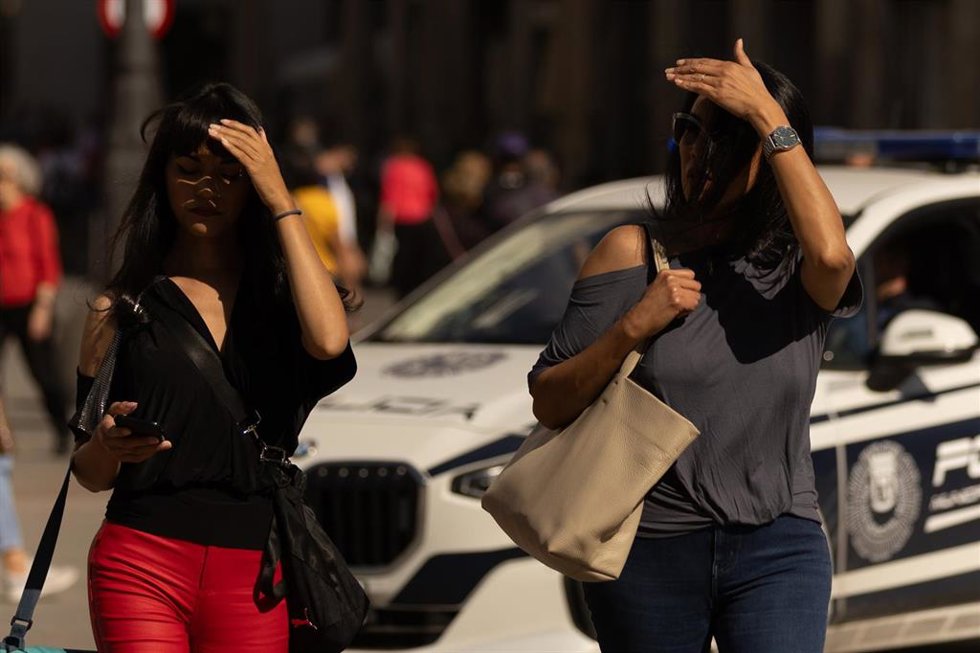 Varias personas usan sus manos para taparse del sol, a 6 de octubre de 2023, en Madrid (España).