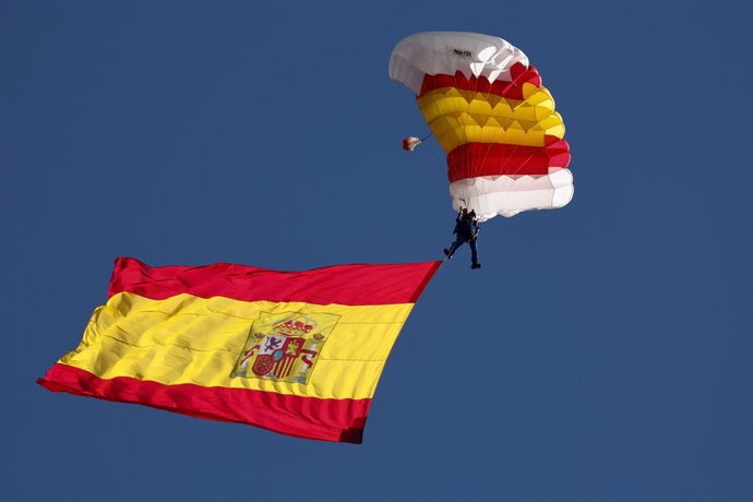 Archivo - La bandera de España con uno de los miembros de la patrulla paracaídista del Ejército del Aire, durante el acto solemne de homenaje a la bandera nacional y desfile militar en el Día de la Hispanidad, a 12 de octubre de 2022, en Madrid (España). 