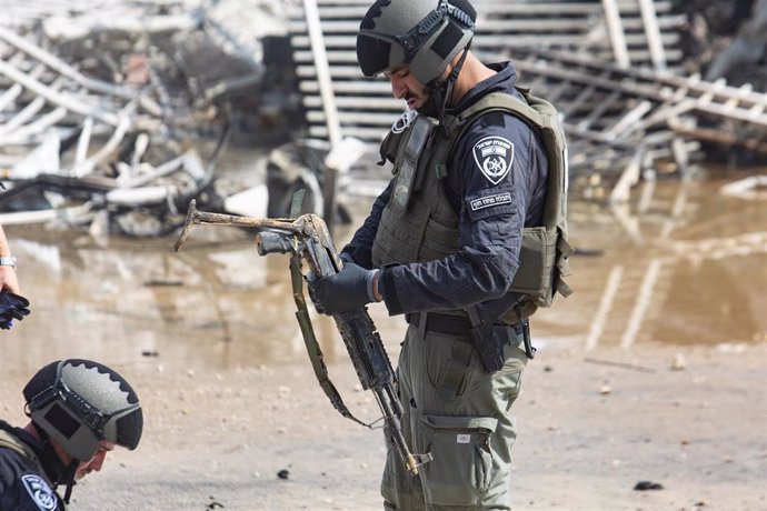 Policías israelíes con un arma incautada a milicianos palestinos en Sderot