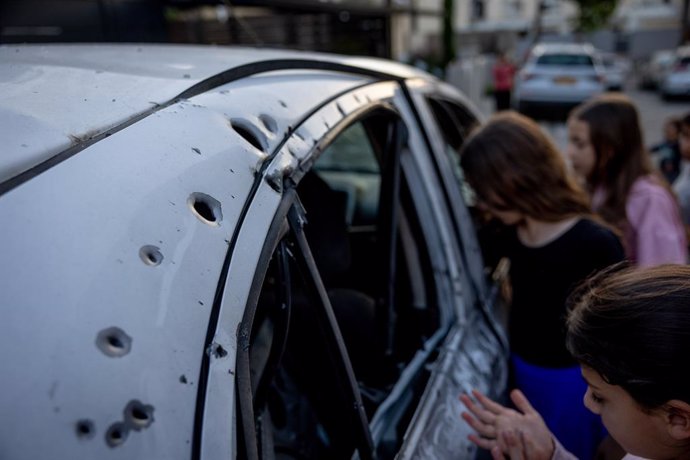 Archivo - SDEROT (ISRAEL), May 3, 2023  -- People check a car after it was attacked by a rocket in southern Israeli town of Sderot, May 2, 2023. Israeli media reported that at least nine people, including a Chinese worker, were injured after one of the 