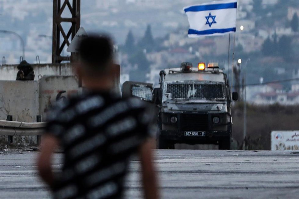 Un joven palestino frente a las fuerzas de seguridad israelíes durante enfrentamientos en Cisjordania