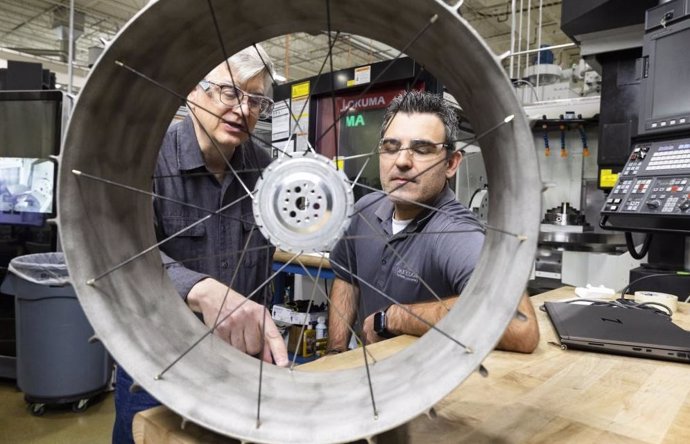 El ingeniero de diseño mecánico de la NASA, Richard Hagen, izquierda, y el investigador de ORNL, Michael Borish, inspeccionan un prototipo de rueda de vehículo lunar que fue impreso en 3D en las instalaciones de demostración de fabricación.