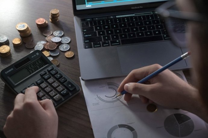 Archivo - Foto recurso manos, dinero, calculadora. Imagen de archivo.