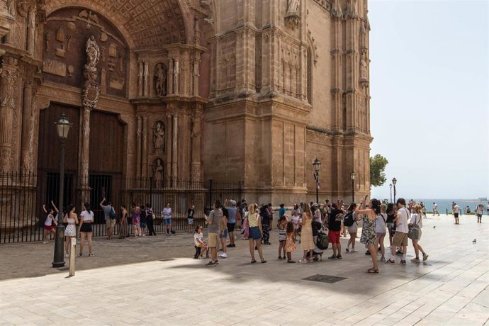 Archivo - Turistas paseando por Palma, frente a la Catedral.