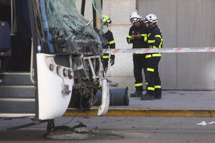 Los bomberos tratan de quitar un árbol caído sobre el autobús que perdió el control a la entrada de Cádiz causando tres fallecidos y dos heridos, a 09 de octubre del 2023 en Cádiz (Andalucía, España).