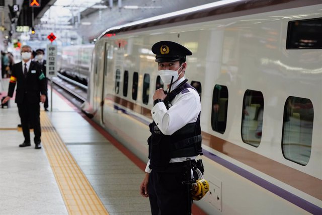 Archivo - Empleados uniformados de la Central Japan Railway Company junto a un tren bala