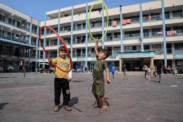 Niños palestinos que huyeron de sus hogares debido a los ataques aéreos y de artillería israelíes jugando mientras se refugian en una escuela en la ciudad de Gaza