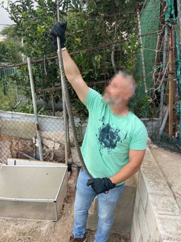 Un agente de la Policía Local con la serpiente rescatada.