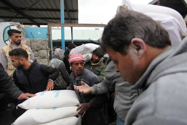 Archivo - Imagen de archivo de varios palestinos recibiendo ayuda y alimentos en un centro de distribución gestionado por la Agencia de Naciones Unidas para los Refugiados Palestinos en Oriente Próximo (UNRWA) en Gaza.