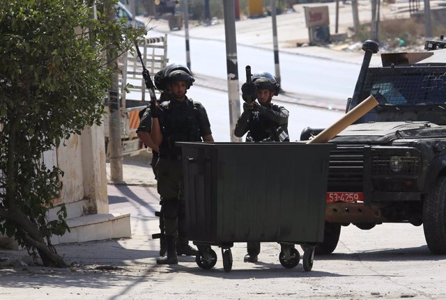 HUWARA, Oct. 6, 2023  -- Israeli soldiers take positions during clashes with Palestinian protesters in the town of Huwara, south of the West Bank city of Nablus, on Oct. 6, 2023. A Palestinian man was shot dead on early Friday near the West Bank city of N