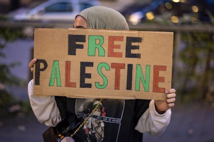 09 October 2023, North Rhine-Westphalia, Duisburg: A woman holds a sign reading "Free Palestine" during a pro-Palestinian rally in Bridge Square. Photo: Christoph Reichwein/dpa