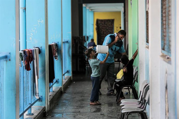 Desplazados palestinos refugiados en una escuela de la Agencia de Naciones Unidas para los Refugiados de Palestina en Oriente Próximo (UNRWA) en la Franja de Gaza a causa de los bombardeos de Israel
