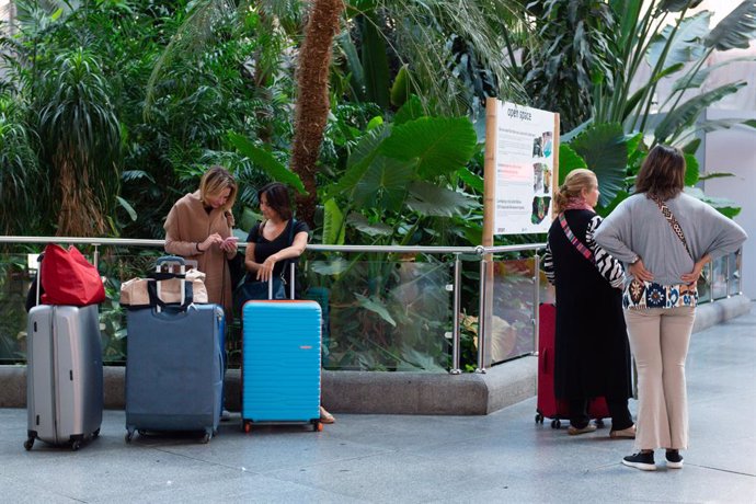 Varias personas esperan con maletas en la estación de Puerta de Atocha-Almudena Grandes, con motivo del inicio del puente del Pilar, a 11 de octubre de 2023