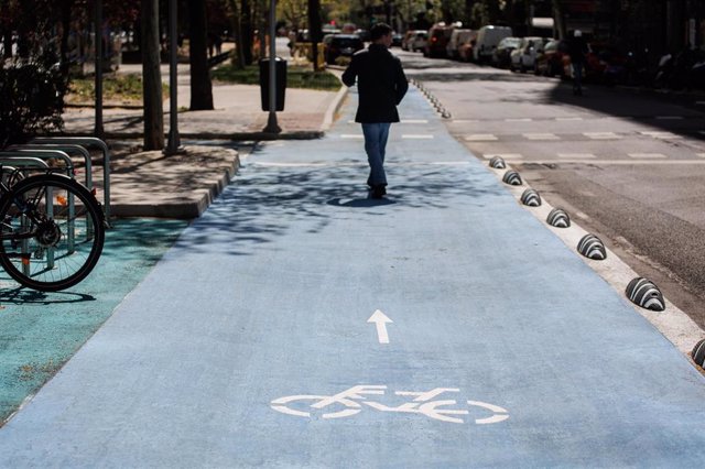 Archivo - Una persona camina por el nuevo carril bici del Paseo de la Castellana, a 3 de abril de 2023, en Madrid (España).