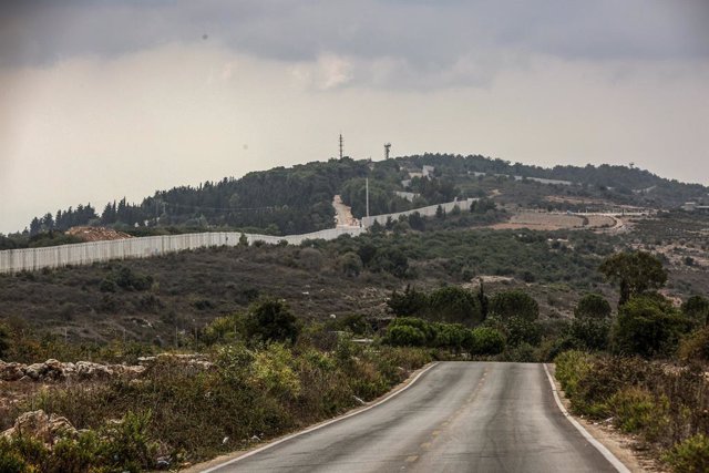 11 October 2023, Lebanon, Dhayra: The Israeli erected border wall and an Israeli military post are seen from a deserted road of the Lebanese southern border village of al Bustan. Photo: Marwan Naamani/dpa