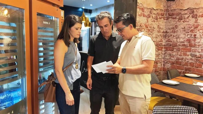 Los parlamentarios andaluces del PP de Almería Manuel Guzmán y Ángeles Martínez en un comercio.