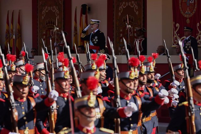 Archivo - El Rey Felipe VI mientras desfila la Guardia Real durante el acto solemne de homenaje a la bandera nacional y desfile militar en el Día de la Hispanidad 