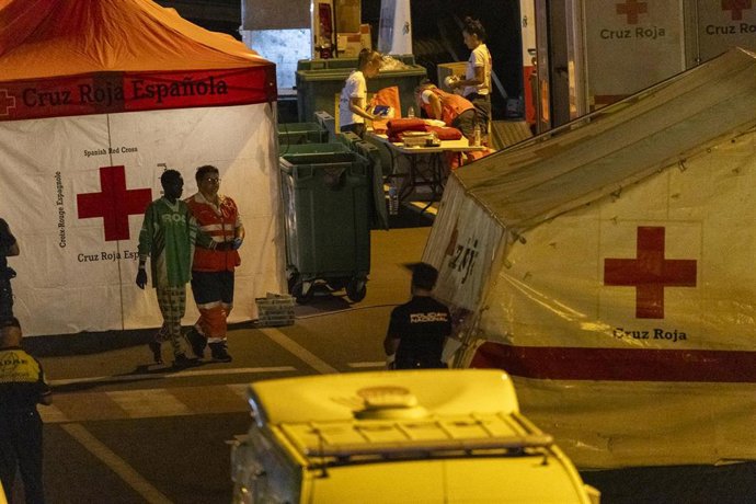 Una sanitaria acompaña a uno de los migrantes a su llegada al Muelle los cristianos en la patrullera de la Guardia Civil Río Tajo, a 11 de octubre de 2023, en Tenerife, Islas Canarias (España)