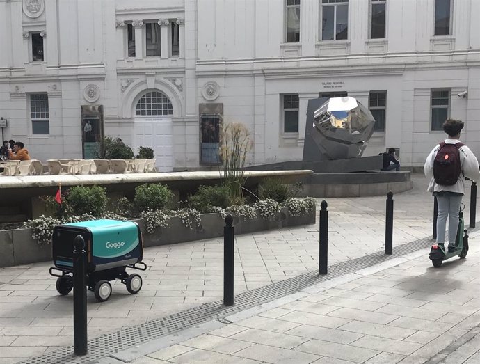 Archivo - Un carrito de transporte autónomo y un patinete