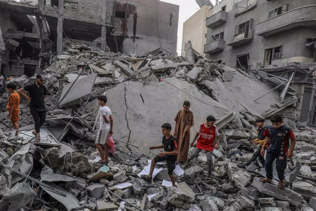 10 October 2023, Palestinian Territories, Khan Yunis: Palestinian children walk among the rubble of a destroyed building, following an Israeli air attack on Khan Yunis. The Israeli military said early Tuesday that it had retaken full control of the border