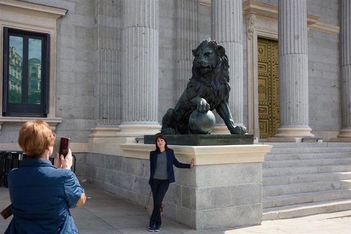 Archivo - Un turista toma fotografías frente al Congreso de los Diputados, en Madrid (España). 